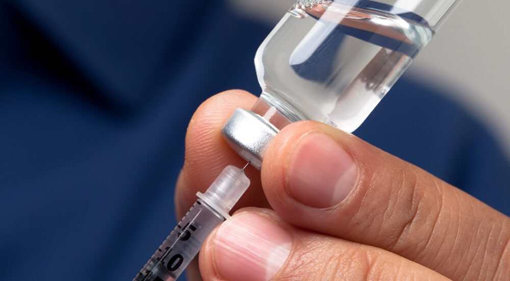 Communications lessons from the Eli Lilly story - hand holding an insulin syringe