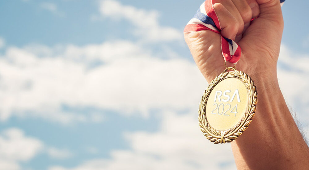 Hand holding an RSA 2024 olympic gold metal