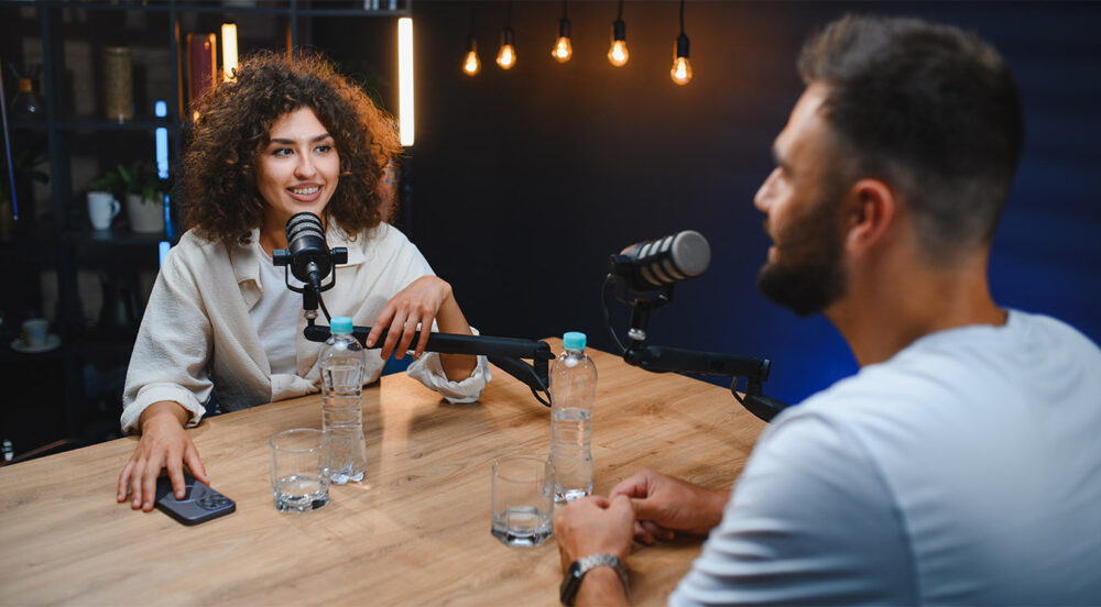Content creator interviewing business executive for paid podcast in modern studio