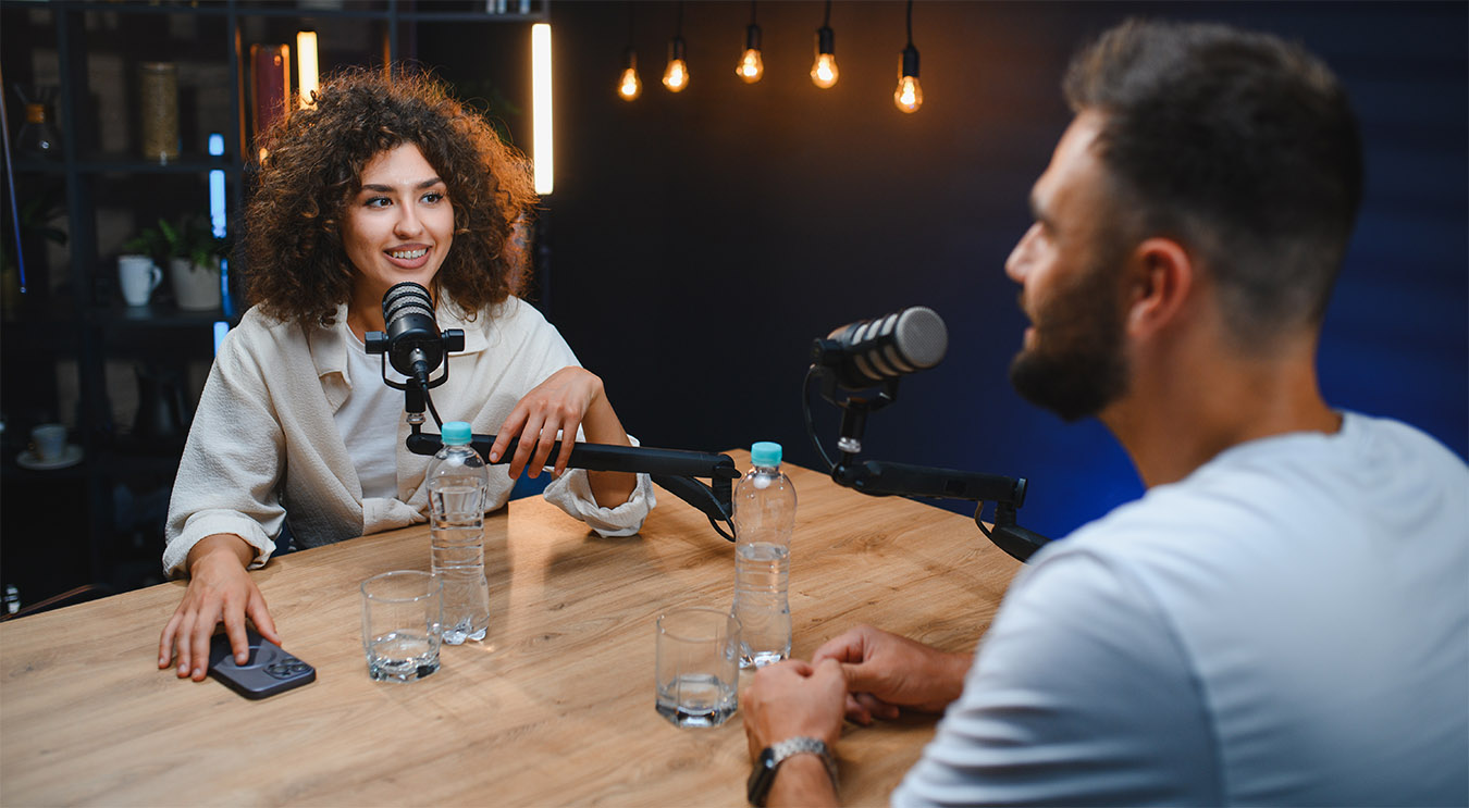 Content creator interviewing business executive for paid podcast in modern studio