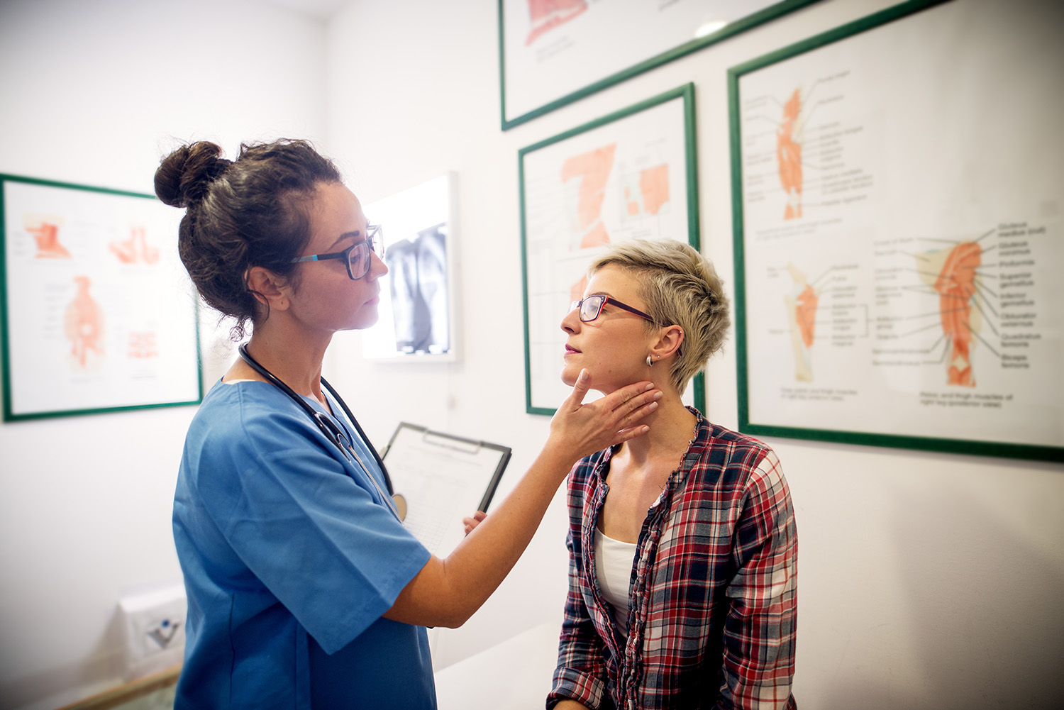 Professional medical doctor examining patient in her office.